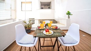 A balcony with a table set for breakfast, including fruits and juice, surrounded by white chairs. - Seaside Getaways by Interhome (Armação de Pêra)