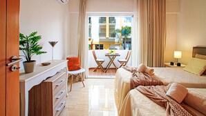A hotel room with a bed, a desk, a chair, a small table with a plant, and a window with curtains. - Seaside Getaways by Interhome (Armação de Pêra)