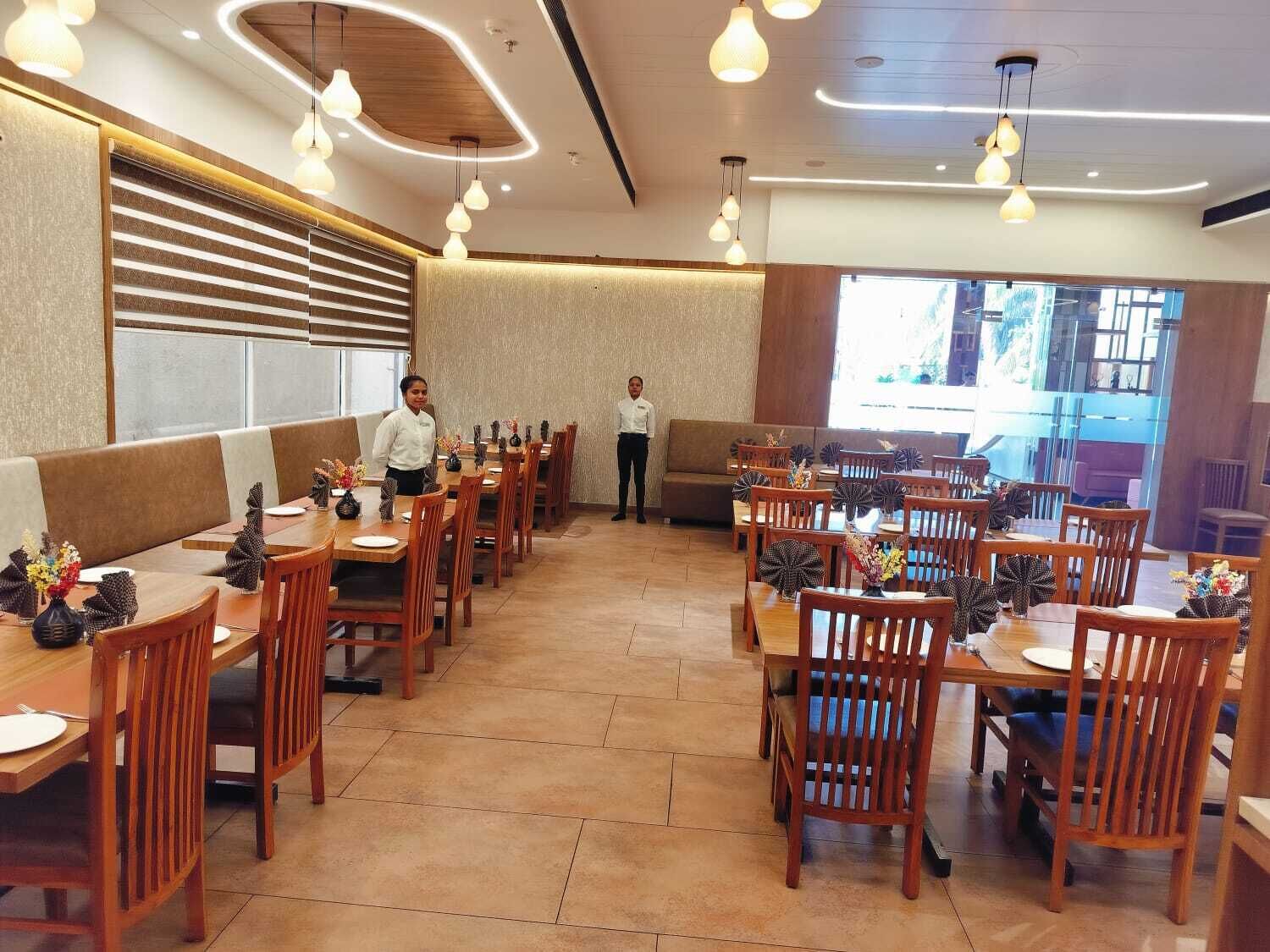 A restaurant with wooden tables and chairs, a bar area, and a view of the outdoors.