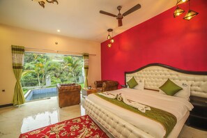 A bedroom with a large bed, a ceiling fan, and a view of a pool and greenery. - Rain Rock Villa (Yercaud)