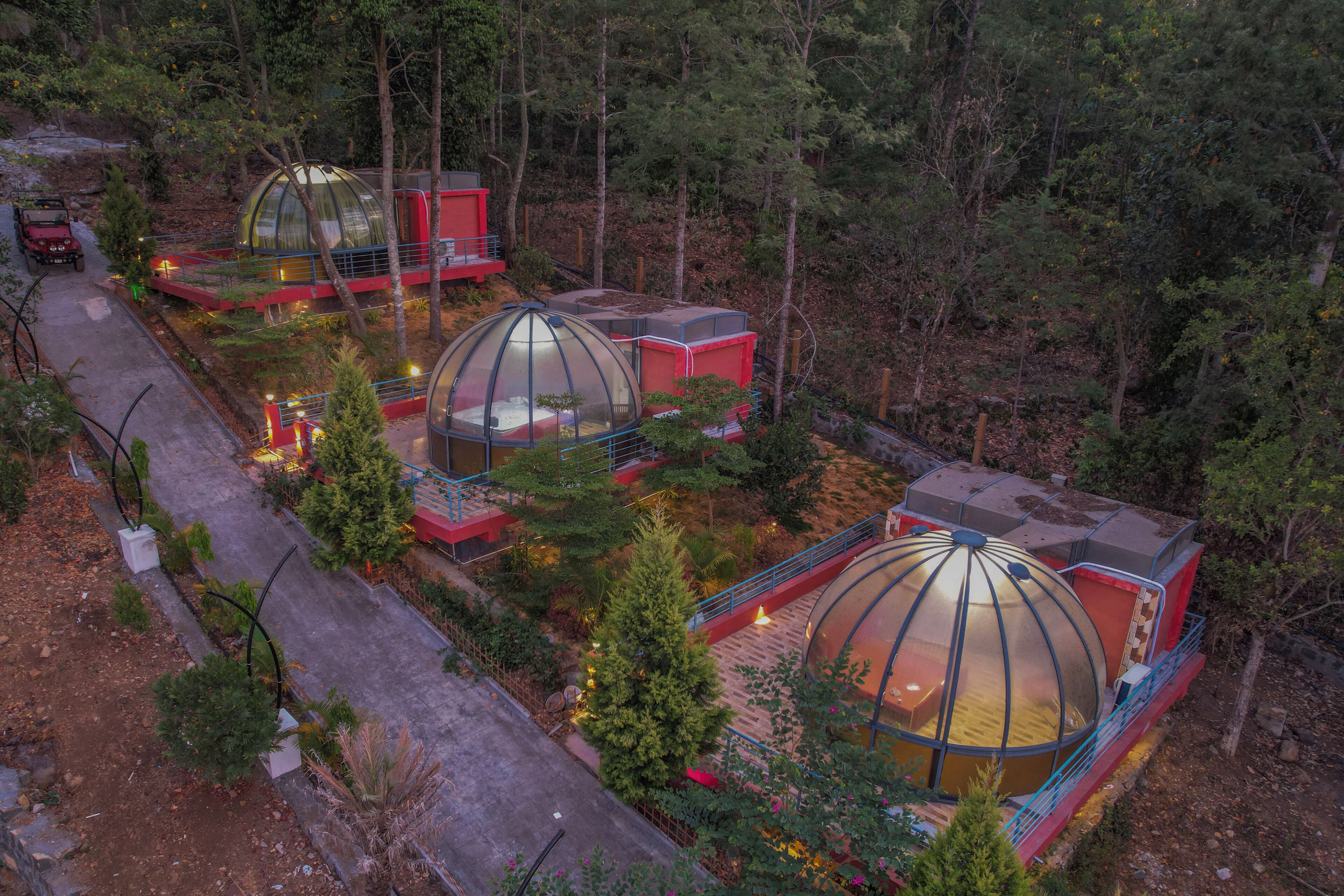 A series of dome-shaped cabins surrounded by trees.