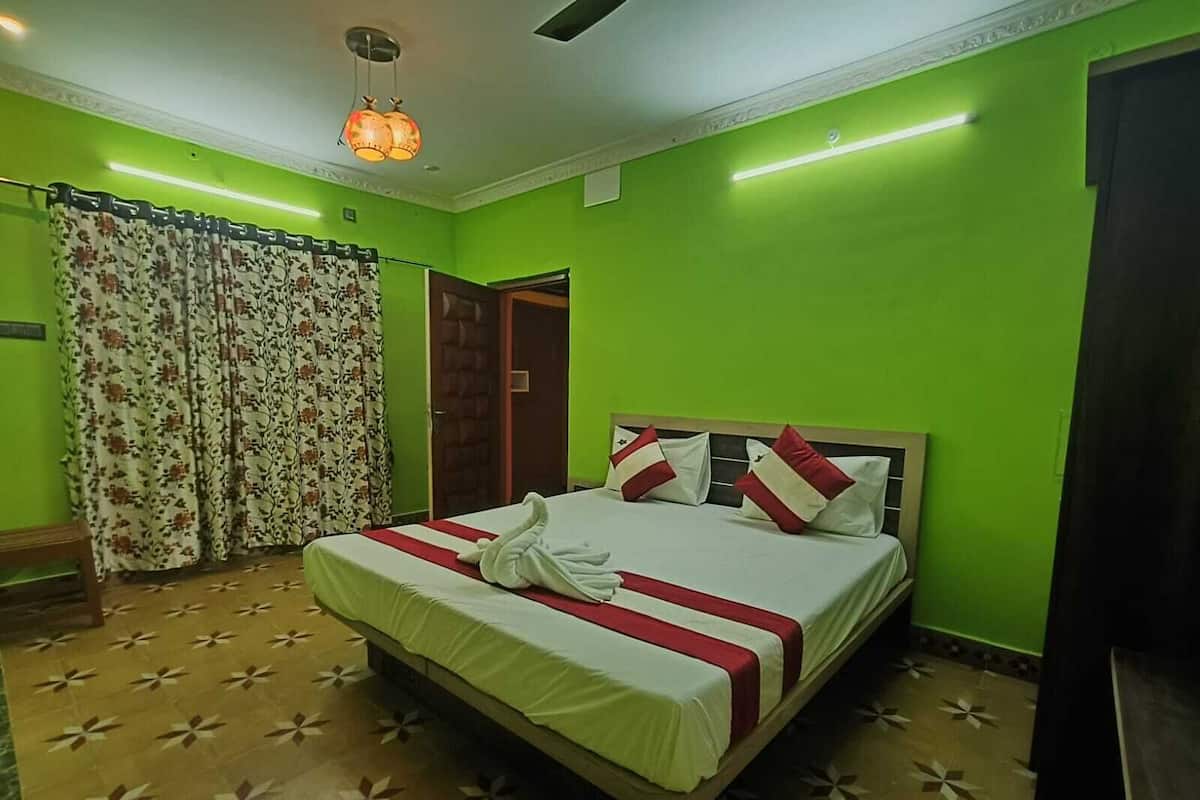 Ein Zimmer mit einem Bett, grünen Wänden, einem blumigen Vorhang und einem gemusterten Boden.