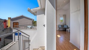A modern hotel room with a balcony, a staircase, and a seating area with a sofa and table. - Casa Lorenzo OG - Ap 2 - 1.kat (Premantura)