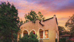 A single-story house with a curved roof, a front porch with three arches, and a staircase leading to the entrance. - Historic Spanish Charm + Scenic View | Cozy Casita (Birmingham)