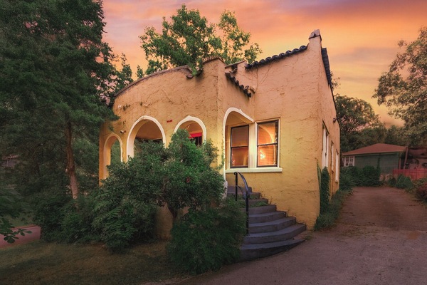 Charming 1925 Spanish Revival home with glowing arches, cozy porch & private drive.