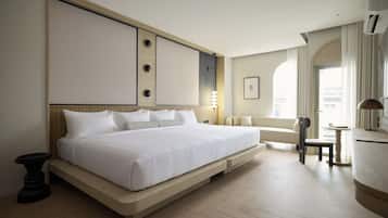 Ein modernes Hotelzimmer mit einem großen Bett, einem kleinen Tisch und einem Sessel.