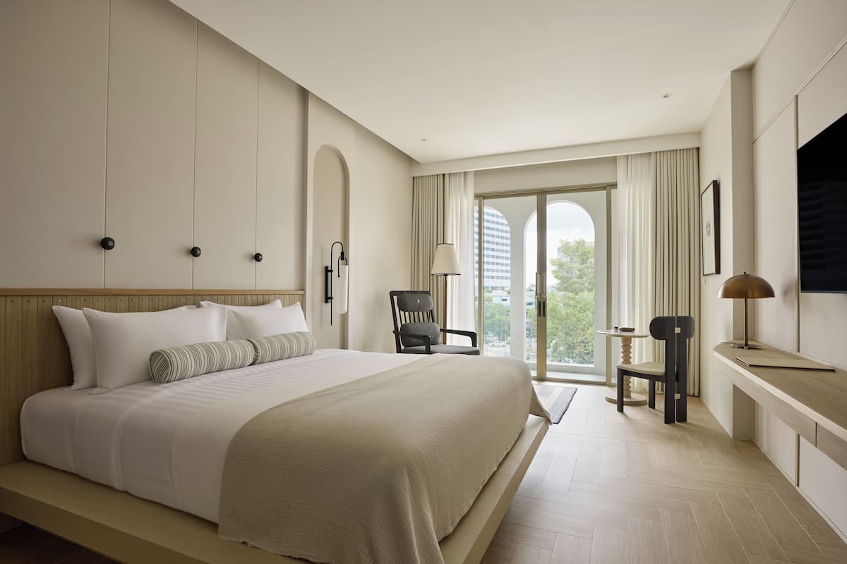Une chambre d’hôtel moderne équipée d’un grand lit, d’un bureau, d’une chaise et d’une télévision.