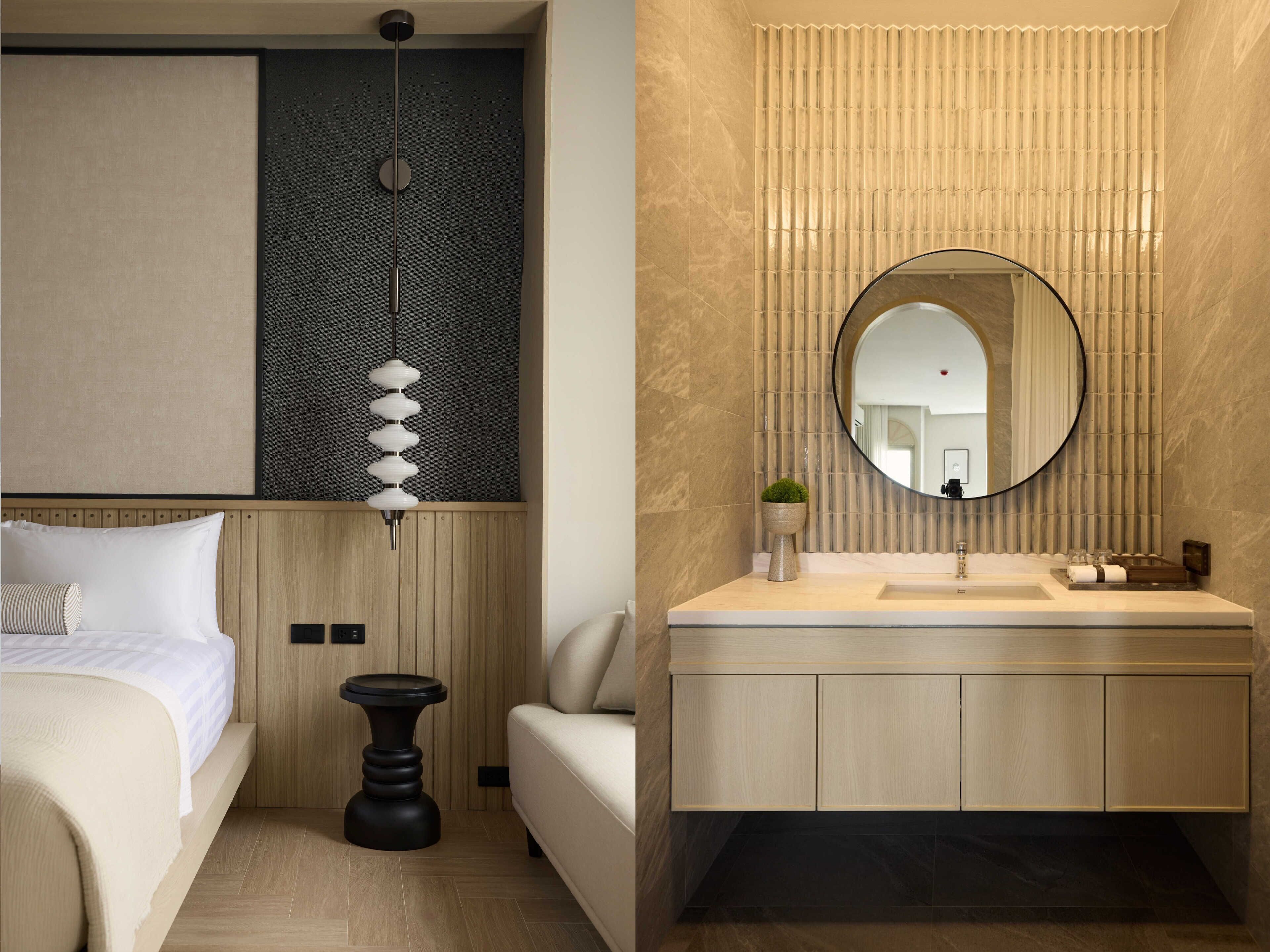 A modern hotel room with a bed, bedside table, and a large mirror above the vanity.