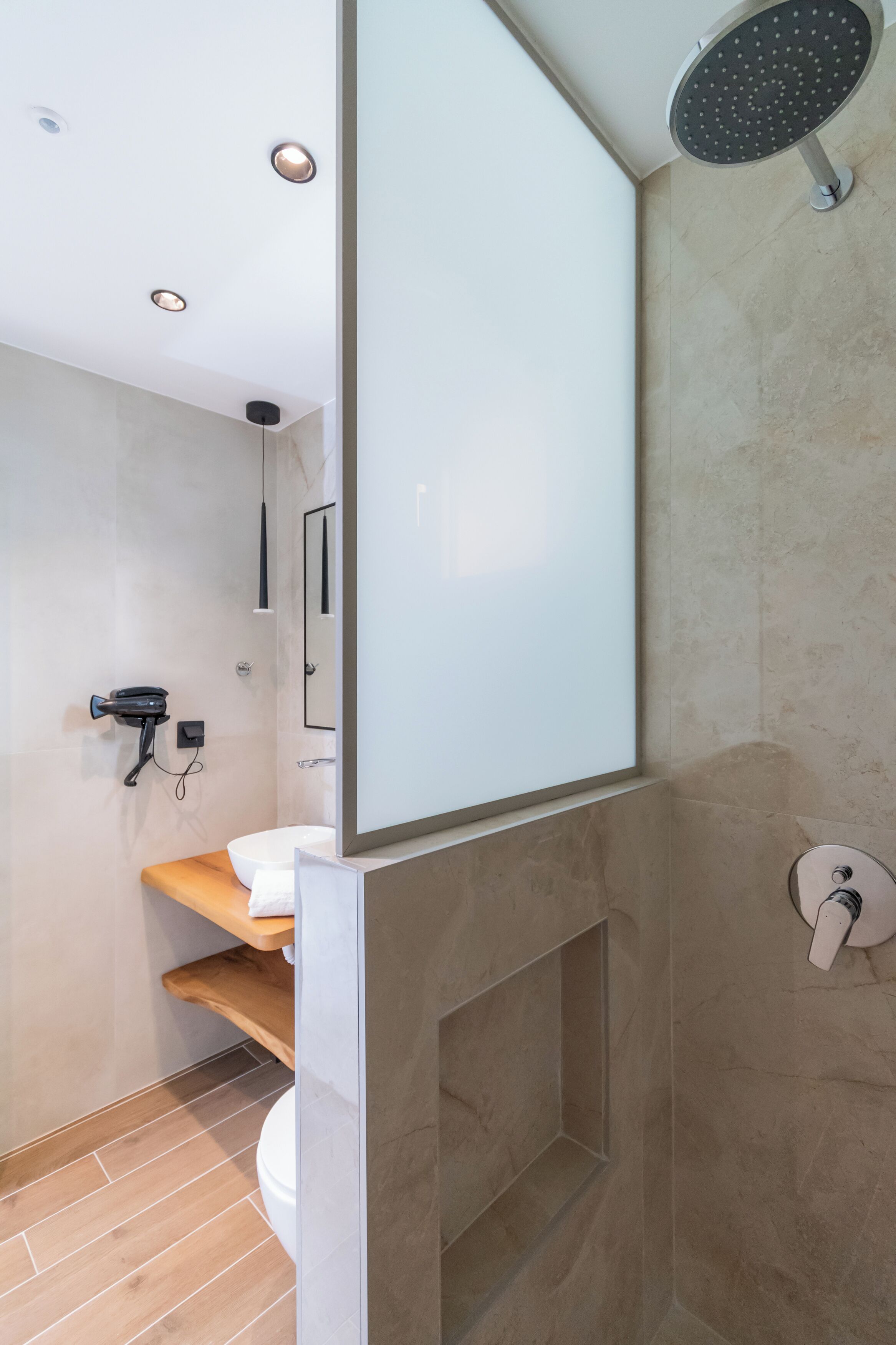 A modern bathroom with a shower, toilet, and sink.