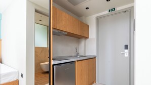 Una cocina moderna con armarios de madera, un lavavajillas de acero inoxidable y un fregadero.