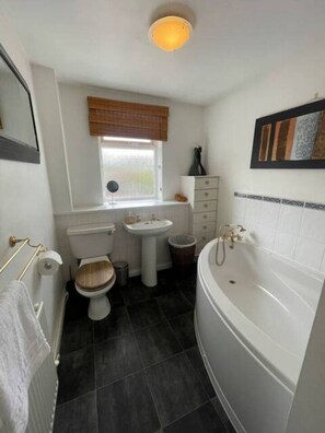 Un baño con inodoro, lavamanos y bañera.