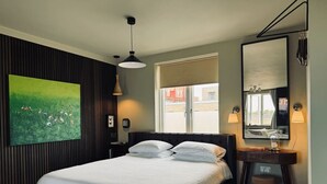 A bedroom with a bed, bedside table, lamp, and a large window with a view of buildings. - Luxury! Modern `Chic` home off Central Mill Road (Cambridge)