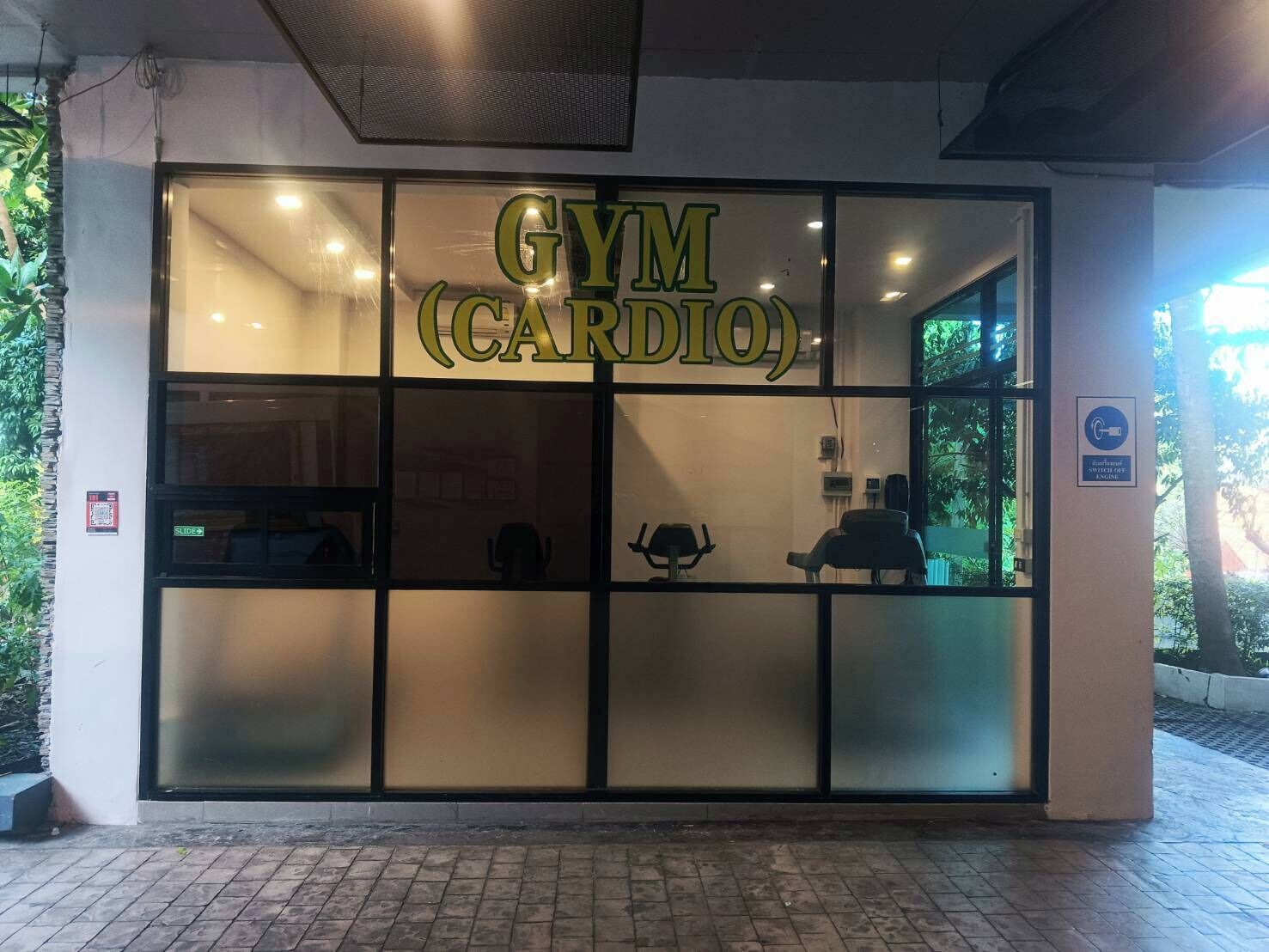 A gym with a glass facade and the name 'GYM (CARDIO)' in large letters.