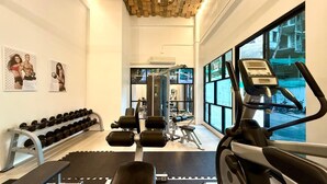 Un gimnasio con equipo de ejercicio, mancuernas y cinta de correr.