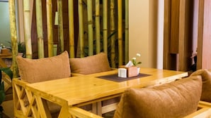 Una mesa de madera con sillas acolchadas, una caja de pañuelos y una planta pequeña sobre la mesa.