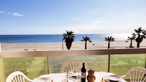 Una mesa para cuatro con vistas a la playa y palmeras.
