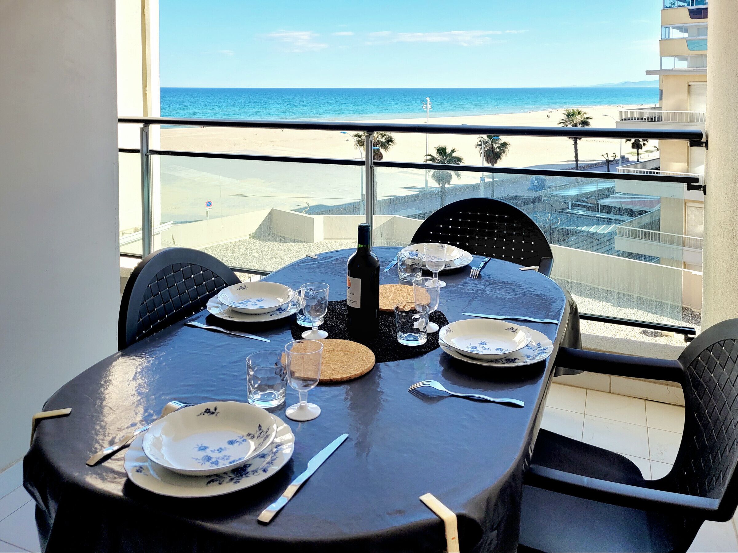 A table set for two with a view of the beach and ocean.