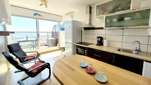 A modern kitchen with a large island, a built-in oven, and a view to the outside. - Canet-en-Roussillon - Studio 2 pers - Sea view - Quiet residence (Canet-en-Roussillon)