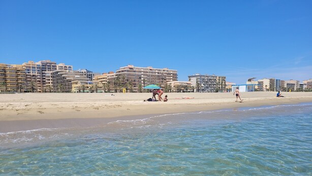 A beach with clear water, a sandy shore, and buildings in the background. - Canet-en-Roussillon - Studio 2 pers - Sea view - Quiet residence (Canet-en-Roussillon)