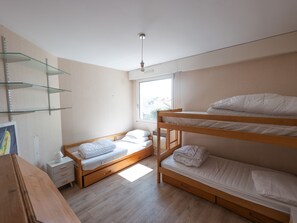 Cozy retreat with a bunk bed setup, bedside table, and natural light.