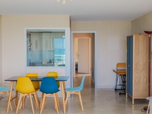 Enjoy meals in this stylish dining area with a view of the adjacent room, featuring a dining table and six chairs.