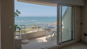 Een balkon met uitzicht op zee, een tafeltje en een stoel.