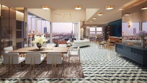 Uma sala de estar moderna com área de jantar, janelas amplas com vista para a cidade e piso estampado.