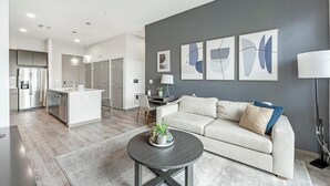 Eine moderne Küche mit Kochinsel, ein Essbereich mit einer Couch und ein Wohnzimmer mit Couchtisch.