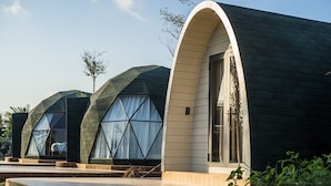 A modern building with a unique geodesic dome design, featuring large windows and a curved entrance. - VinaEcolife Lodge (Tan Xuan)