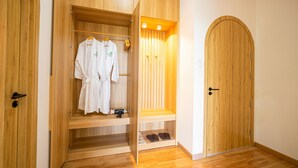 A wooden wardrobe with a hanging rack and shelves, a wooden door, and a wooden floor. - VinaEcolife Lodge (Tan Xuan)