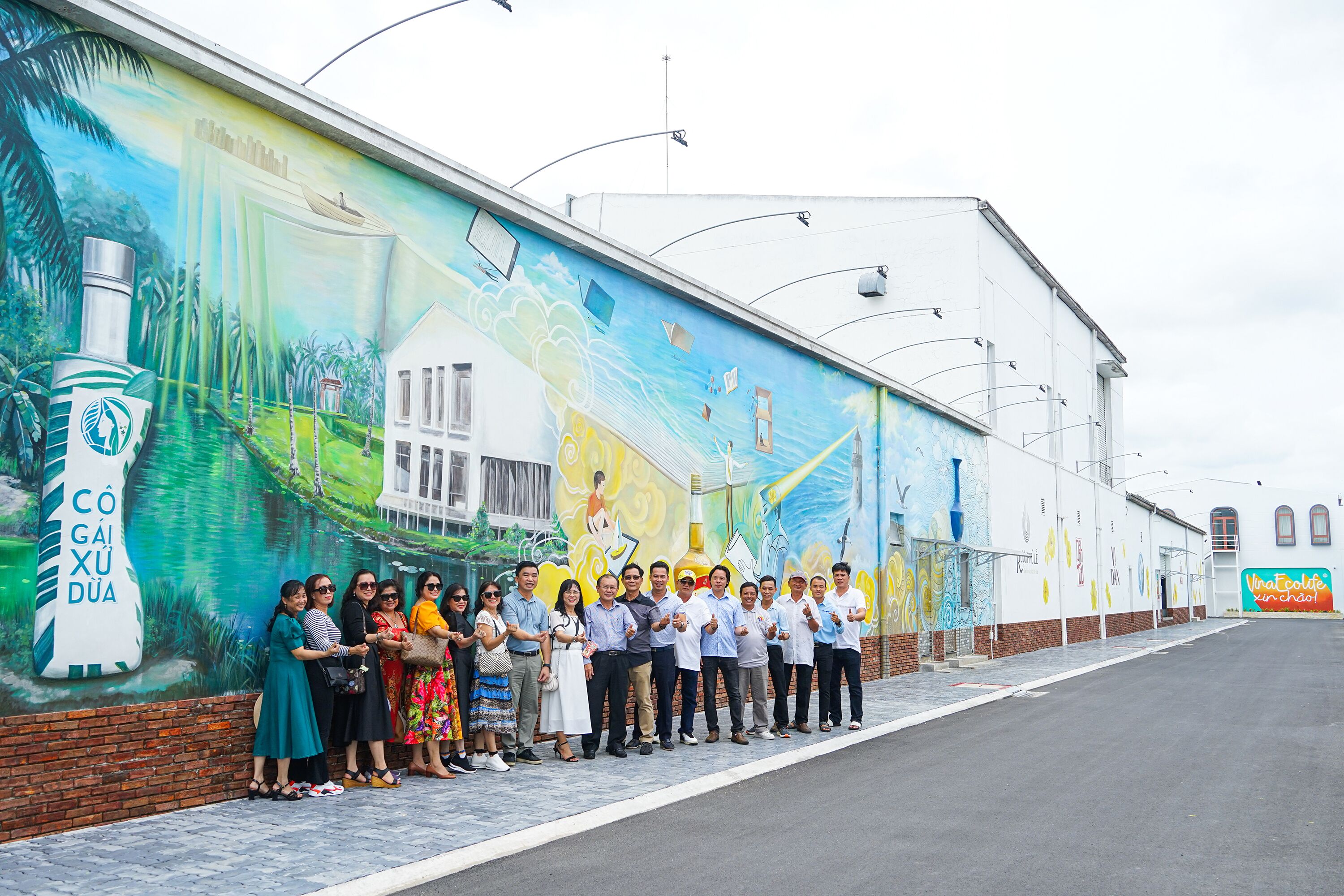 Un grupo de personas frente a un mural en un edificio.