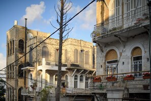 A historic building with arched windows and balconies, featuring stone architecture and a clear sky. - Haifa Downtown Eco Apt by Sea N' Rent (Haifa)