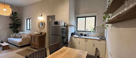 A compact living space with a kitchenette, a dining area, and a seating area.