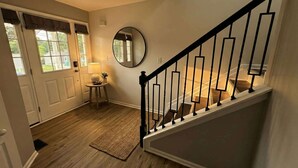 A staircase with a black railing leading to a landing. - Renovated 3BR — King Suite, Laundry, Parking (New Castle)