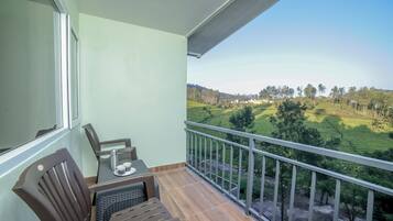 Enjoy a serene view of the surrounding landscape from this balcony, featuring a table and chair.