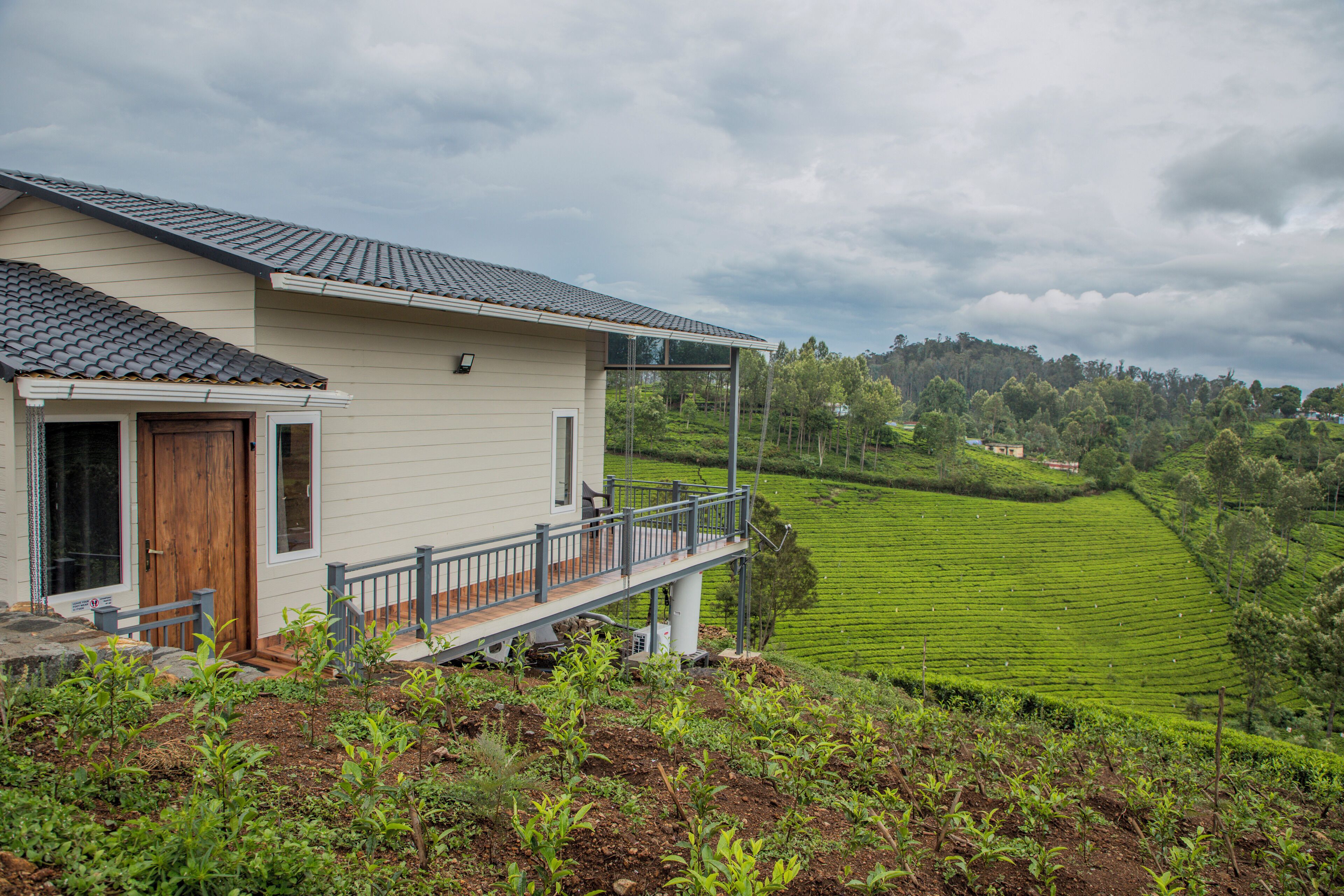 A house with a balcony overlooking a green landscape.