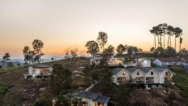 A residential area with houses on a hillside, surrounded by trees and a clear sky. - Wattle Grove Resort (Kotagiri)