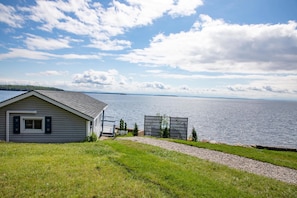 A house with a view of a lake, a gravel path, and a grassy area.