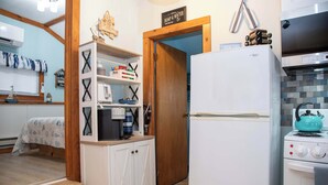 A compact kitchen with a refrigerator, stove, and wooden cabinets. - ZaLo House Waterline cabin with Hot Tub Pets (Peru)
