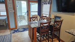 Une cuisine avec un coin repas, un téléviseur et une vue sur l’océan.