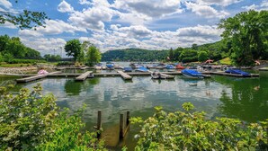 A marina with boats docked, surrounded by greenery and a clear sky. - Remodeled, Family-Friendly Home in Private Community on Candlewood Lake (New Fairfield)