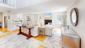 A spacious living area with a kitchen, dining table, and fireplace. - Gorgeous home in Wild Dunes with parking on Palm Blvd. (Isle of Palms)