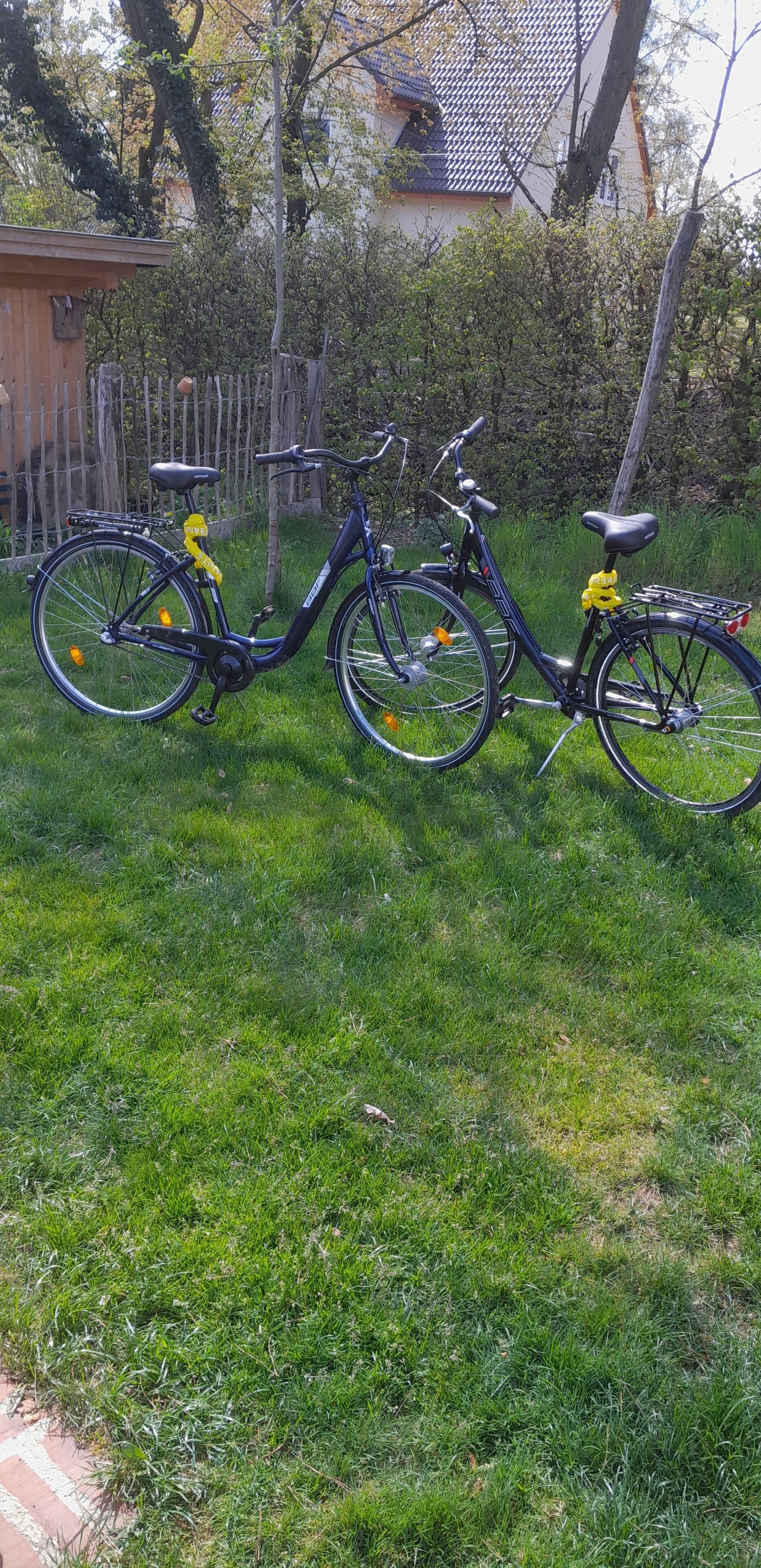 Een zwarte fiets met gele accenten geparkeerd op een gazon.