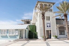 Un bâtiment situé sur la côte, avec une façade blanche, un balcon et une enseigne indiquant « Seaside, Floride ».