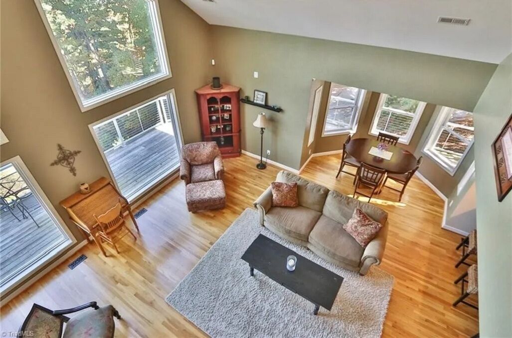 A spacious living room with a large window, a fireplace, and a dining area.
