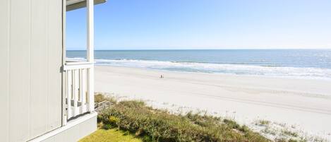 A beachfront property with a balcony overlooking the ocean.