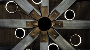 Un plafond doté d’un luminaire circulaire central, entouré de huit autres luminaires circulaires disposés à intervalles réguliers.