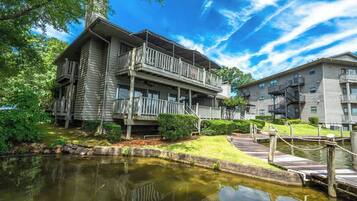 A two-story building with a balcony, a small pond, and a dock.
