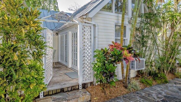 A house with a covered porch, a wooden deck, and a variety of plants. - Get your ISLAND STLYE on! (Key West)
