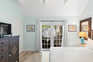 A bedroom with a bed, a television, a dresser, and a window with curtains. - Get your ISLAND STLYE on! (Key West)